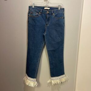 Tory Burch Connor jeans in medium allover stone wash. Cropped. Raffia fringed